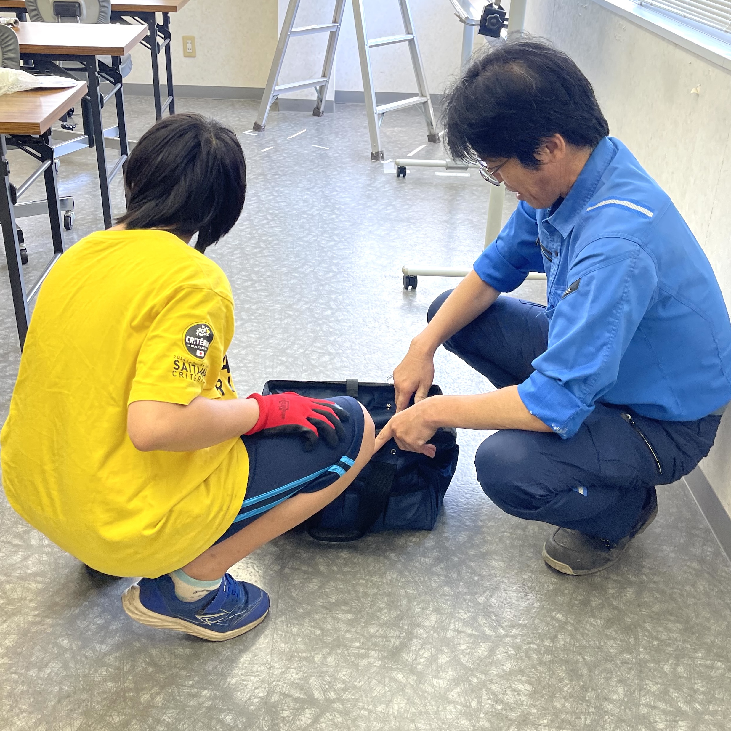 社員と一緒に工具バッグを確認する様子