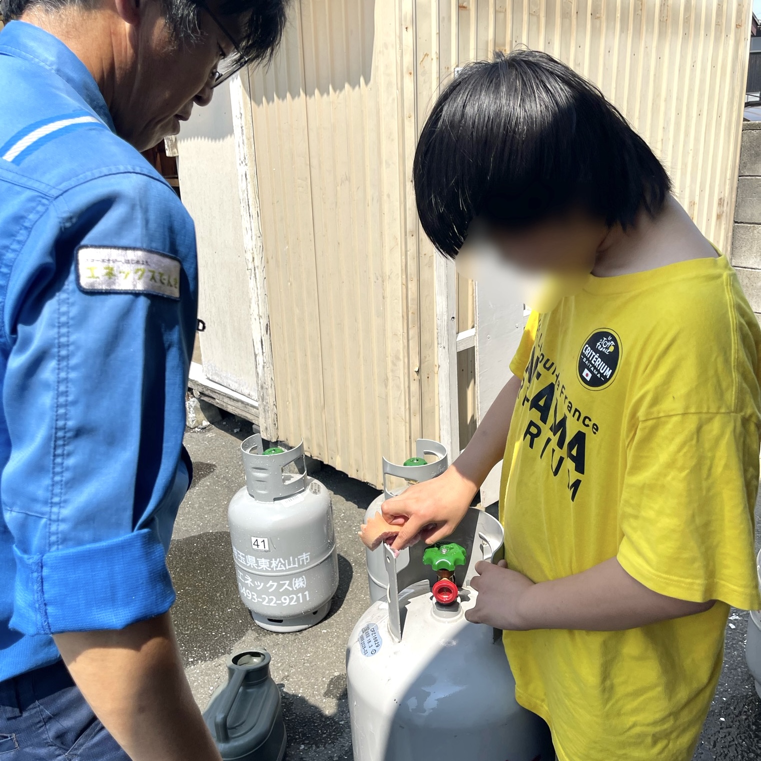 ガスボンベを拭き掃除する様子